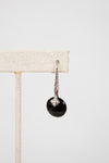 Black faceted bead earring with silver hook on a white background