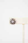 Close up of silver and diamond earring on white background