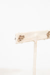 Earring post close up on stand with a white background
