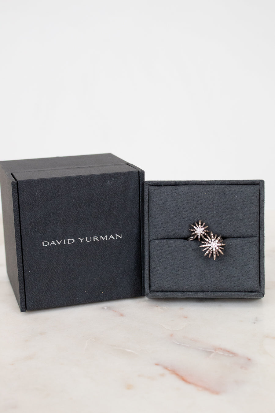 David Yurman earrings in a black box on a marble surface