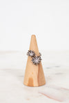 Silver diamond ring on wooden cone with white background