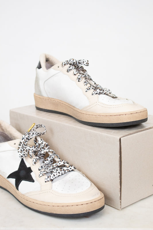 White sneakers with decorative laces on a white background