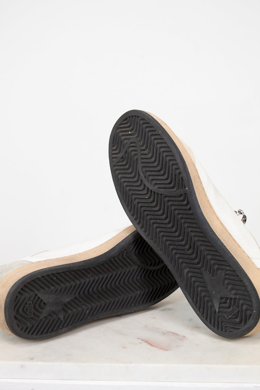 Close-up of a pair of shoes with black soles on a light background