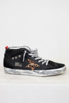 Black high-top sneaker with leopard print star on a white background