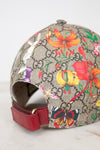 Colorful floral and butterfly patterned cap with Gucci logo on a light gray background