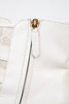 Close-up of a white leather jacket with a gold zipper on a light gray background