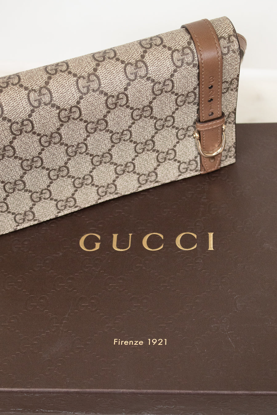 Gucci handbag with brown strap on a Gucci branded box
