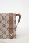 Gucci handbag with brown strap and logo pattern on a white background
