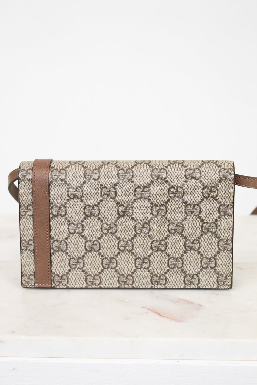Designer handbag with brown and beige pattern on a white background