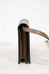 Close-up of a leather wallet with a strap on a white background