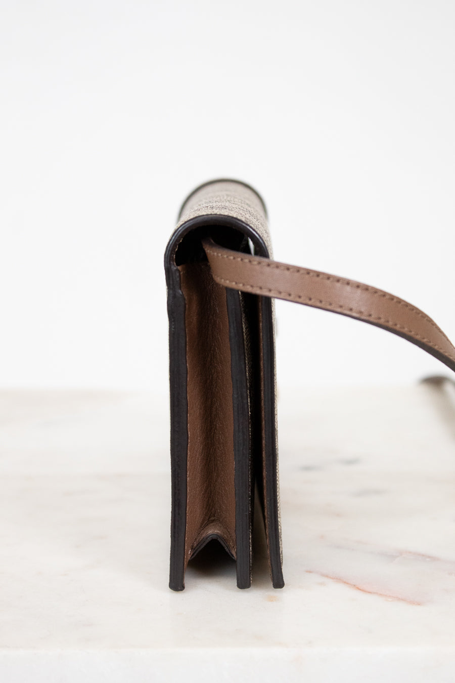 Close-up of a leather wallet with a strap on a white background