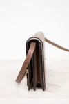 Close-up of a brown leather wallet with a strap on a white background