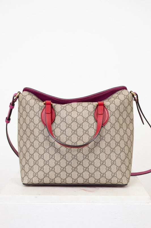 Beige handbag with pink accents on a white background