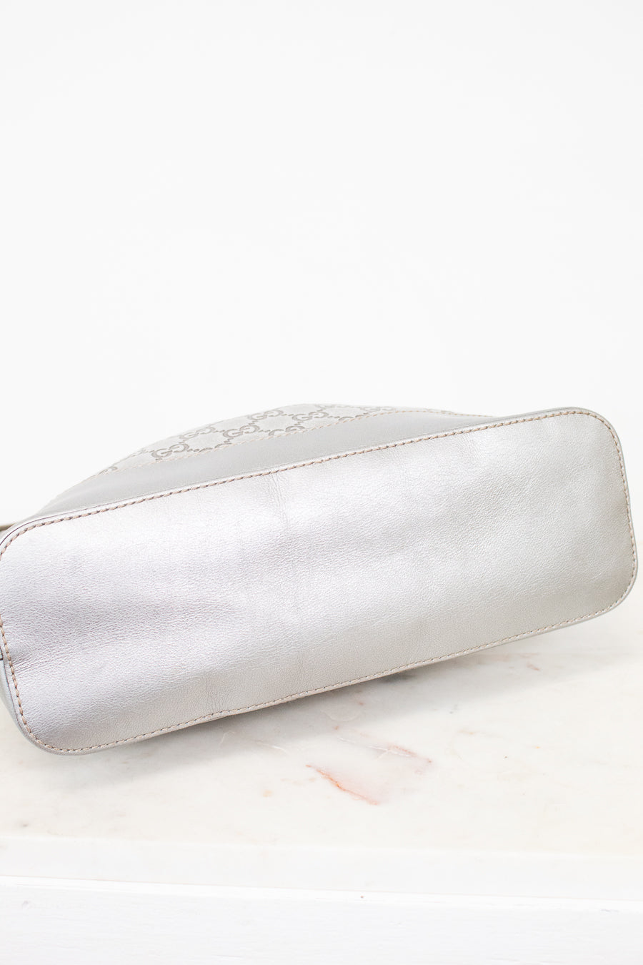 Silver bottom of bag on a marble surface
