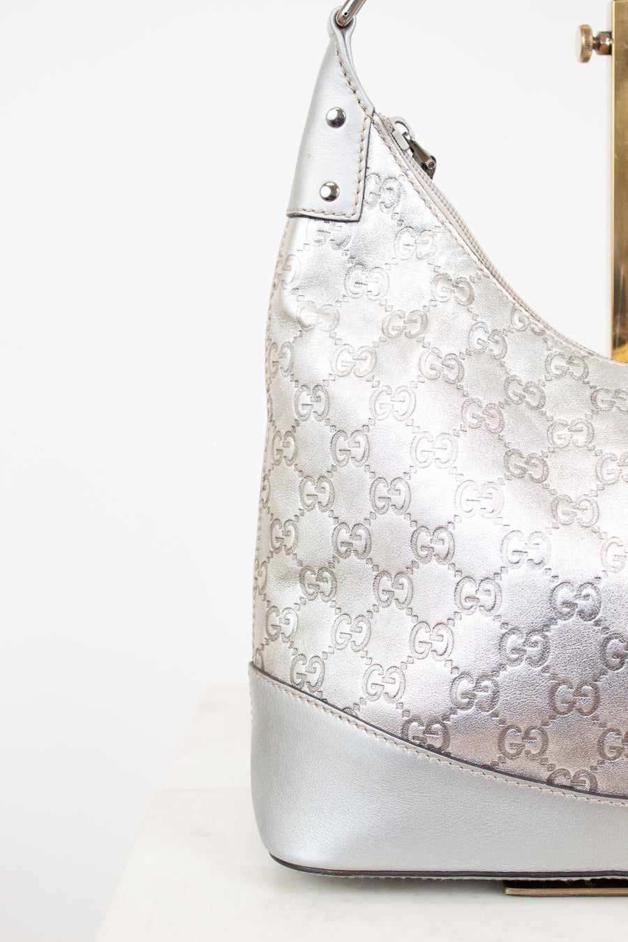 Silver Gucci handbag with logo pattern on a white background