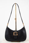Black shoulder bag on gold stand with white background