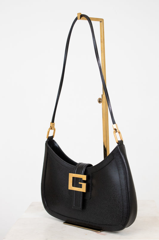 Black handbag with gold accents on a white background