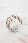 Silver bracelet with intricate designs on a marble surface