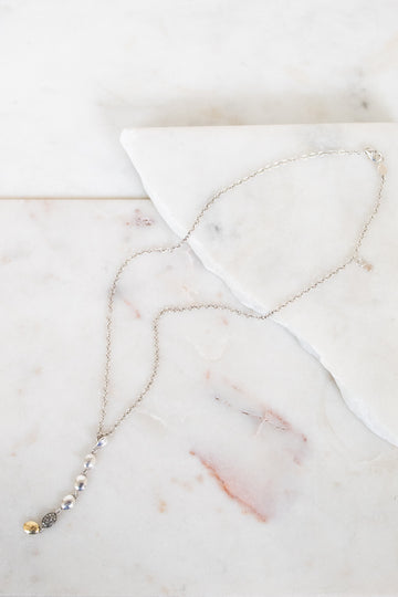 Silver necklace on marble surface