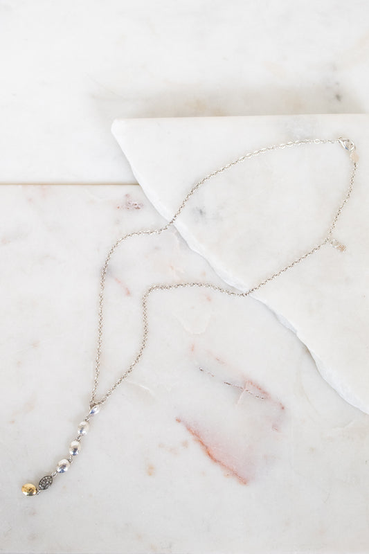 Silver necklace on marble surface