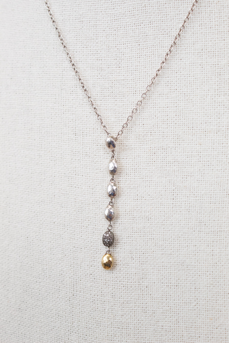 Necklace with hanging beads on a light gray background