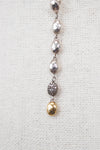 Silver and gold necklace on a textured white background