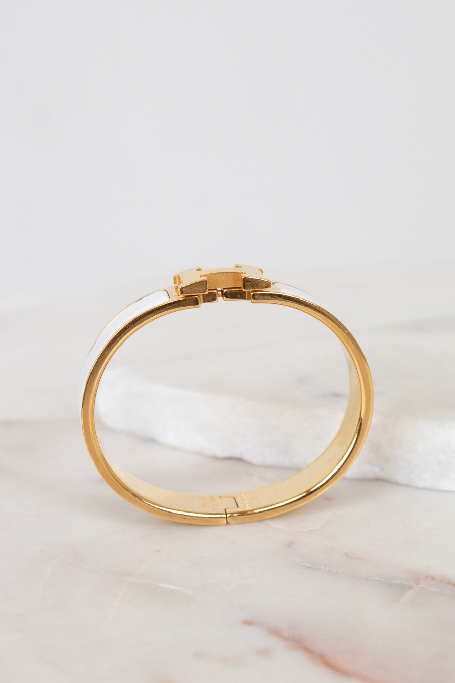 Gold bracelet on a marble surface