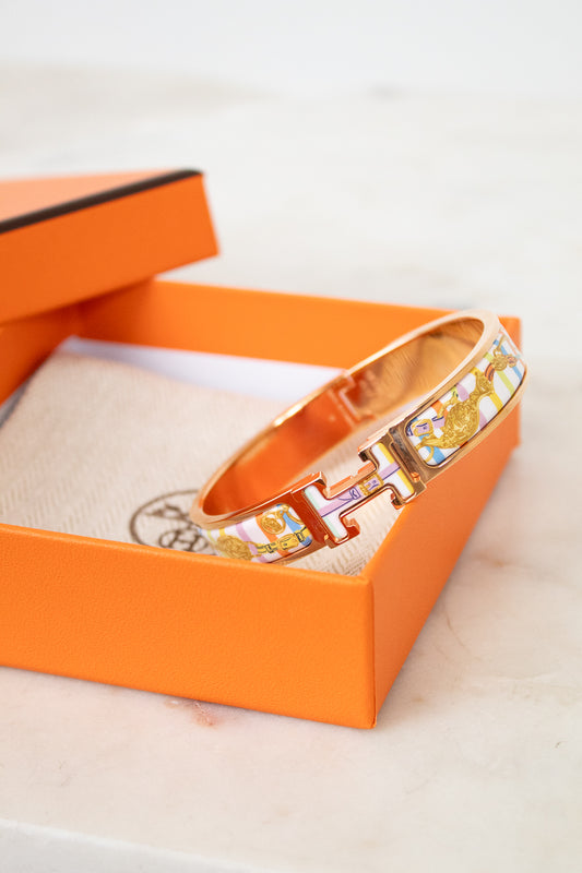 Rose gold bracelet with colorful design on an orange box
