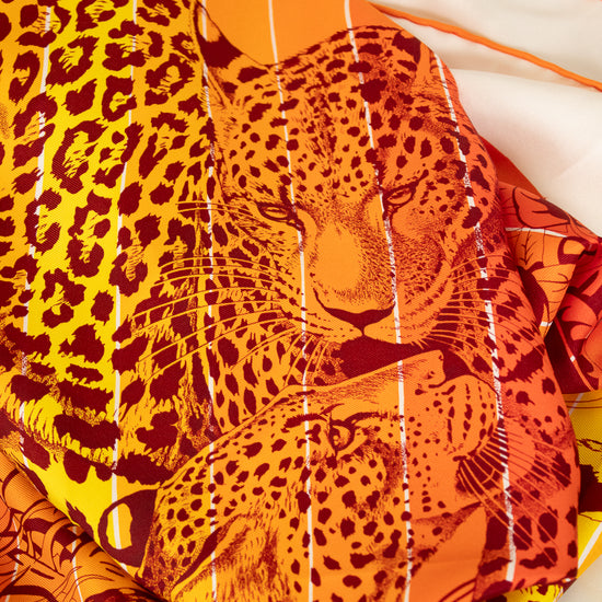 Leopard print scarf with orange and yellow colors on a white background