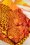 Leopard print scarf with orange and yellow colors on a white background