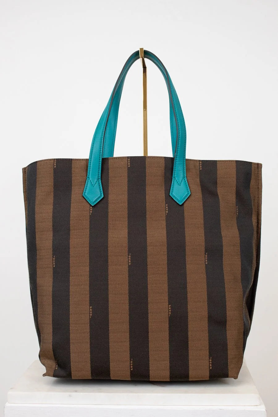Striped tote bag with teal handles on a white background