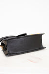 Black handbag with gold accents on a white background