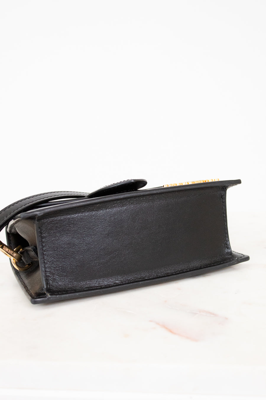 Black handbag with gold accents on a white background