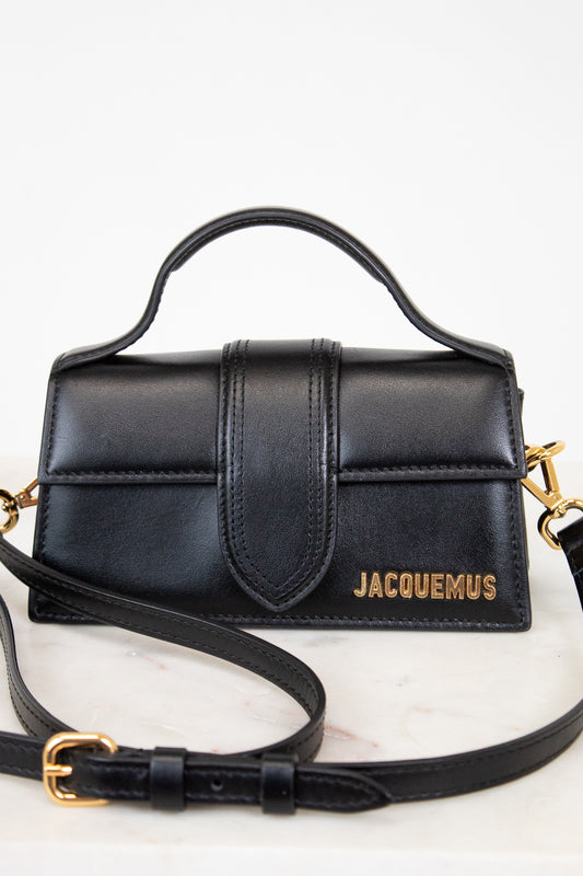 Black handbag with gold accents on a white background