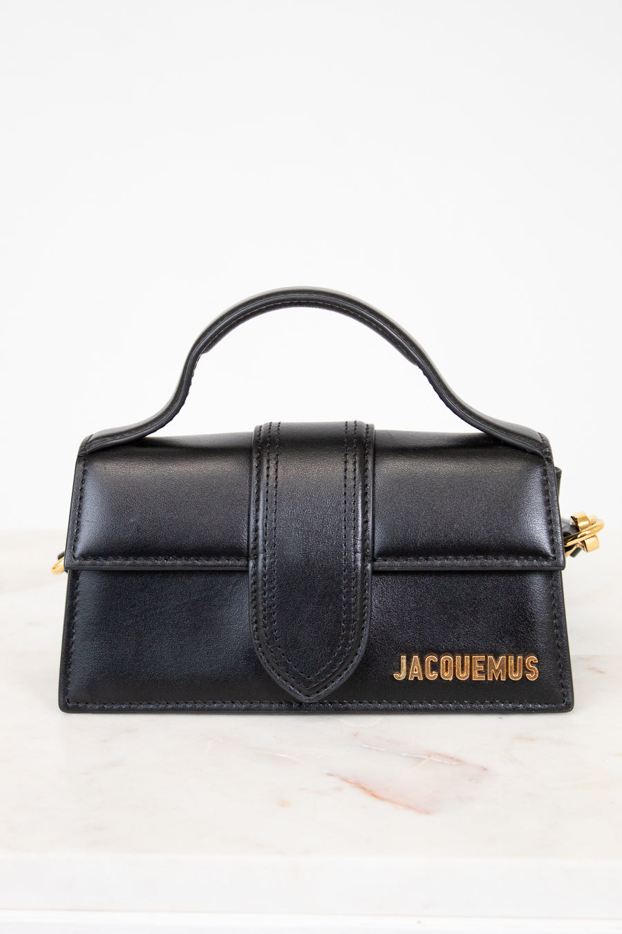 Black handbag with 'Jacquemus' branding on a white background