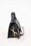 Black handbag with gold clasp on a white background