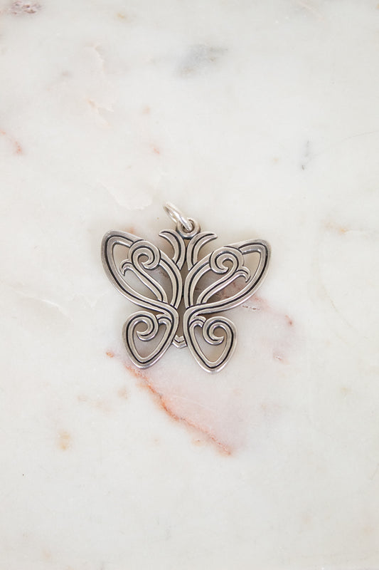 Silver butterfly pendant on a marble background