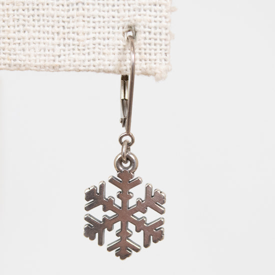 Silver snowflake charm on a white background