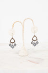 Pair of earrings on a white stand with a white background