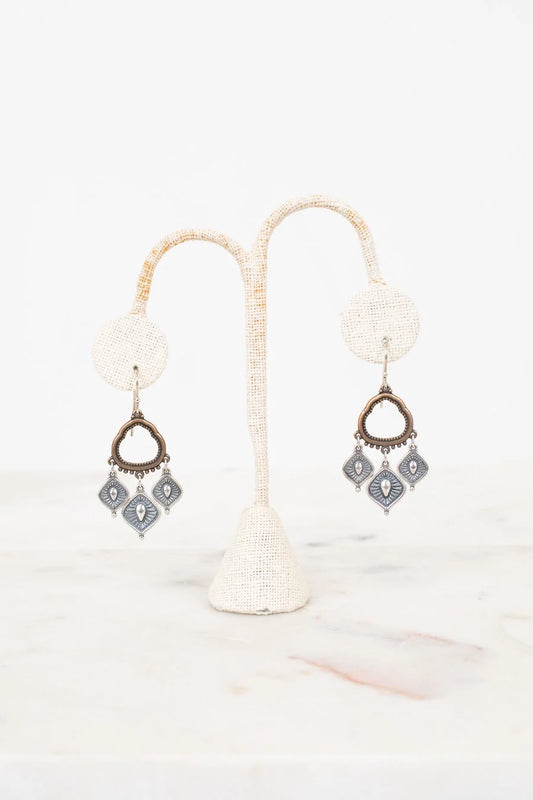 Pair of earrings on a white stand with a white background
