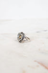 Silver flower-shaped ring on a marble surface
