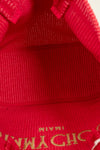 Close-up of a red fabric texture with gold lettering.