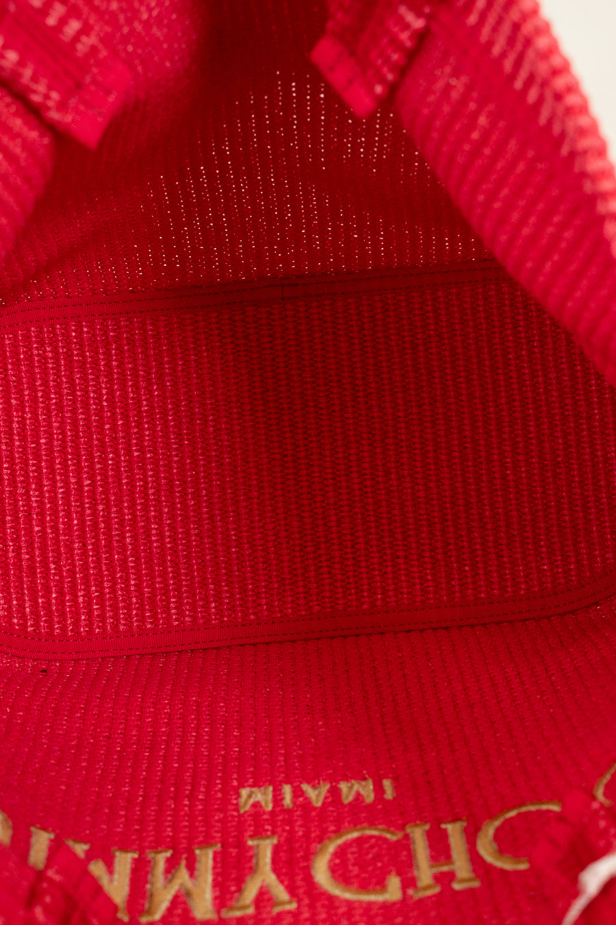 Close-up of a red fabric texture with gold lettering.