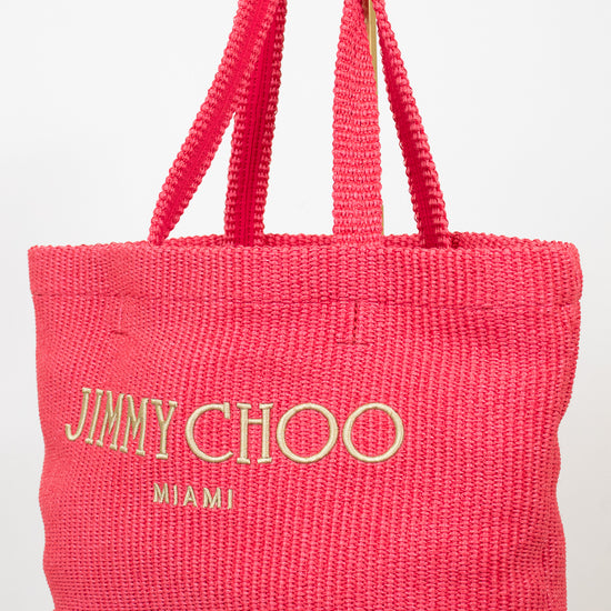 Pink woven handbag with 'Jimmy Choo Miami' text on a white background
