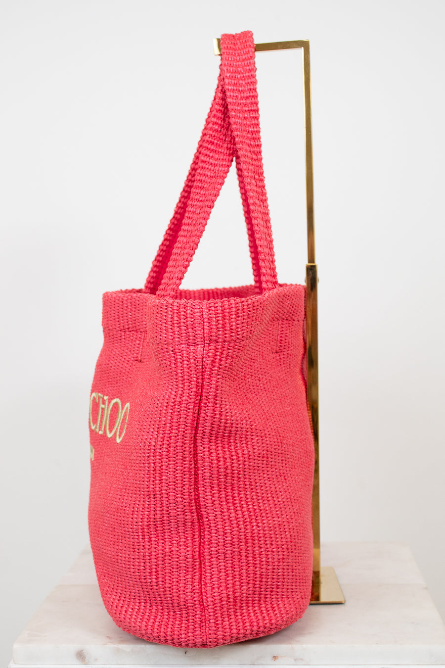 Pink woven bag with 'Jimmy Choo' branding on a white background