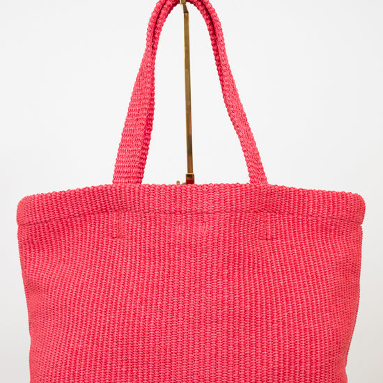 Pink woven handbag on a white background