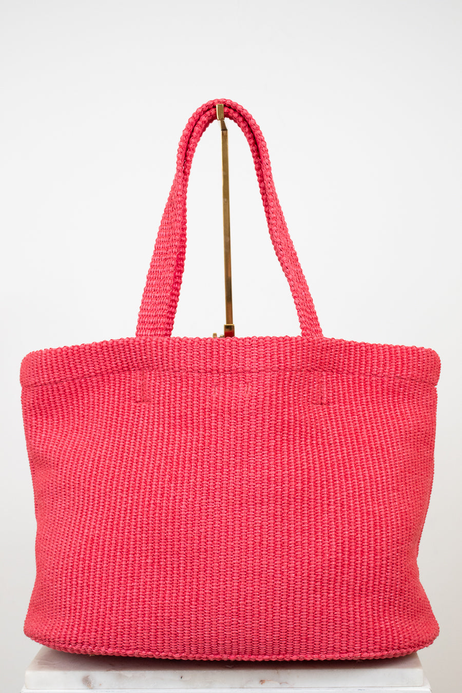 Pink woven handbag on a white background