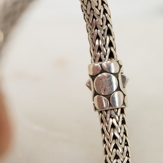 Close-up of a silver bracelet with a blurred background