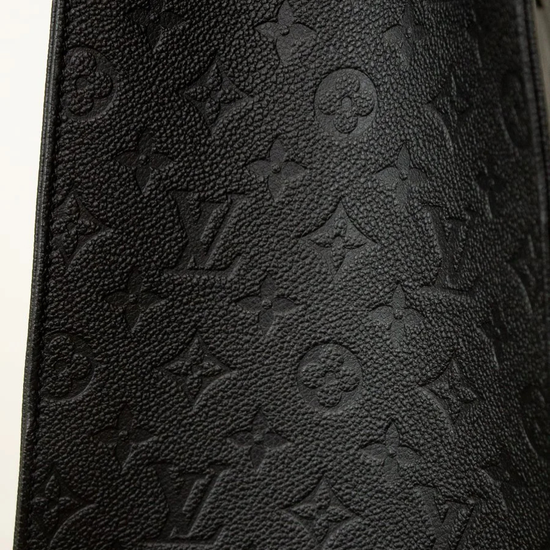 Close-up of a black leather wallet with embossed logo pattern