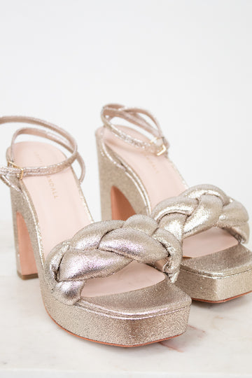 Gold glitter high-heeled sandals on a white background